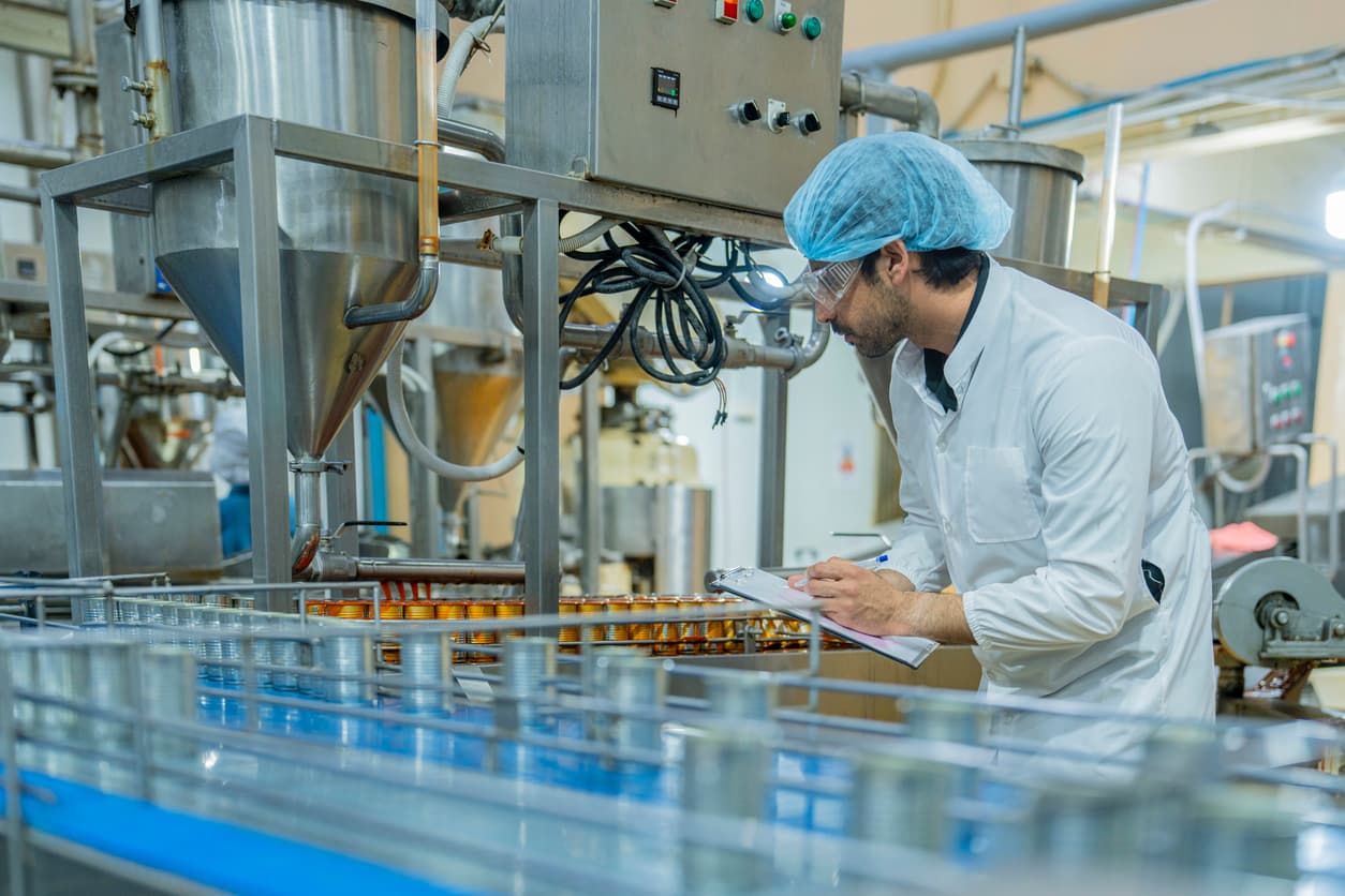 Food quality inspector reviewing a food manufacturing production line